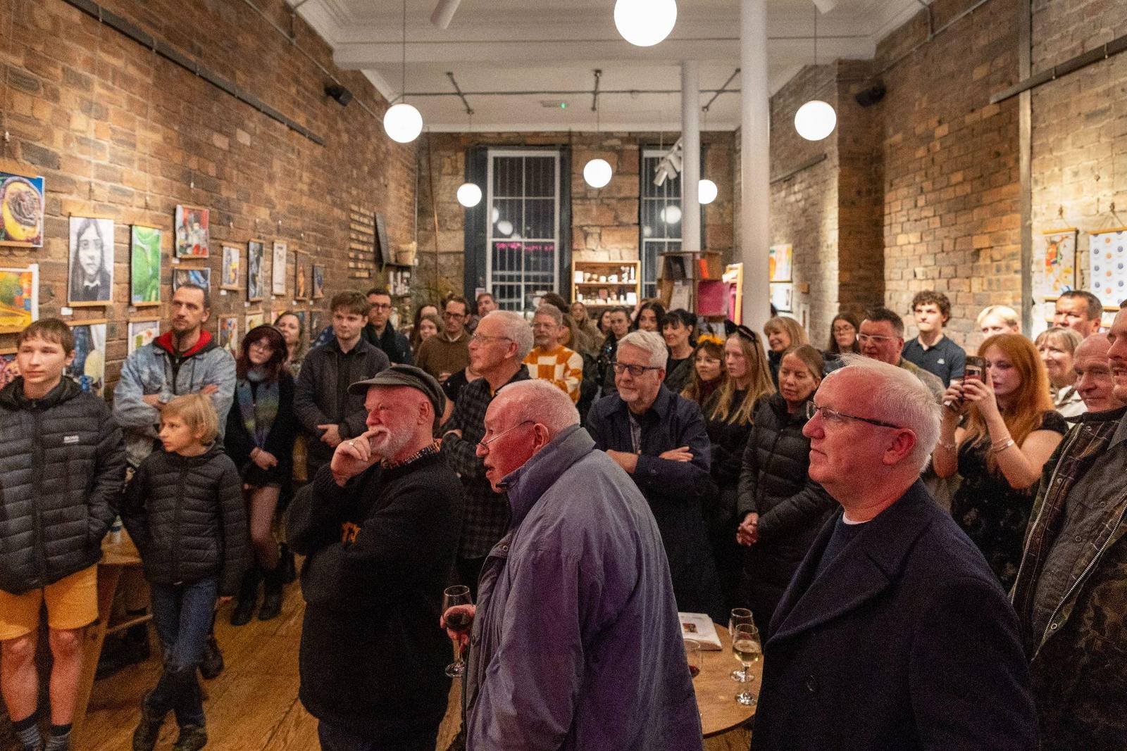 Guests gathered among the hung pupil artworks at the 2025 opening night.