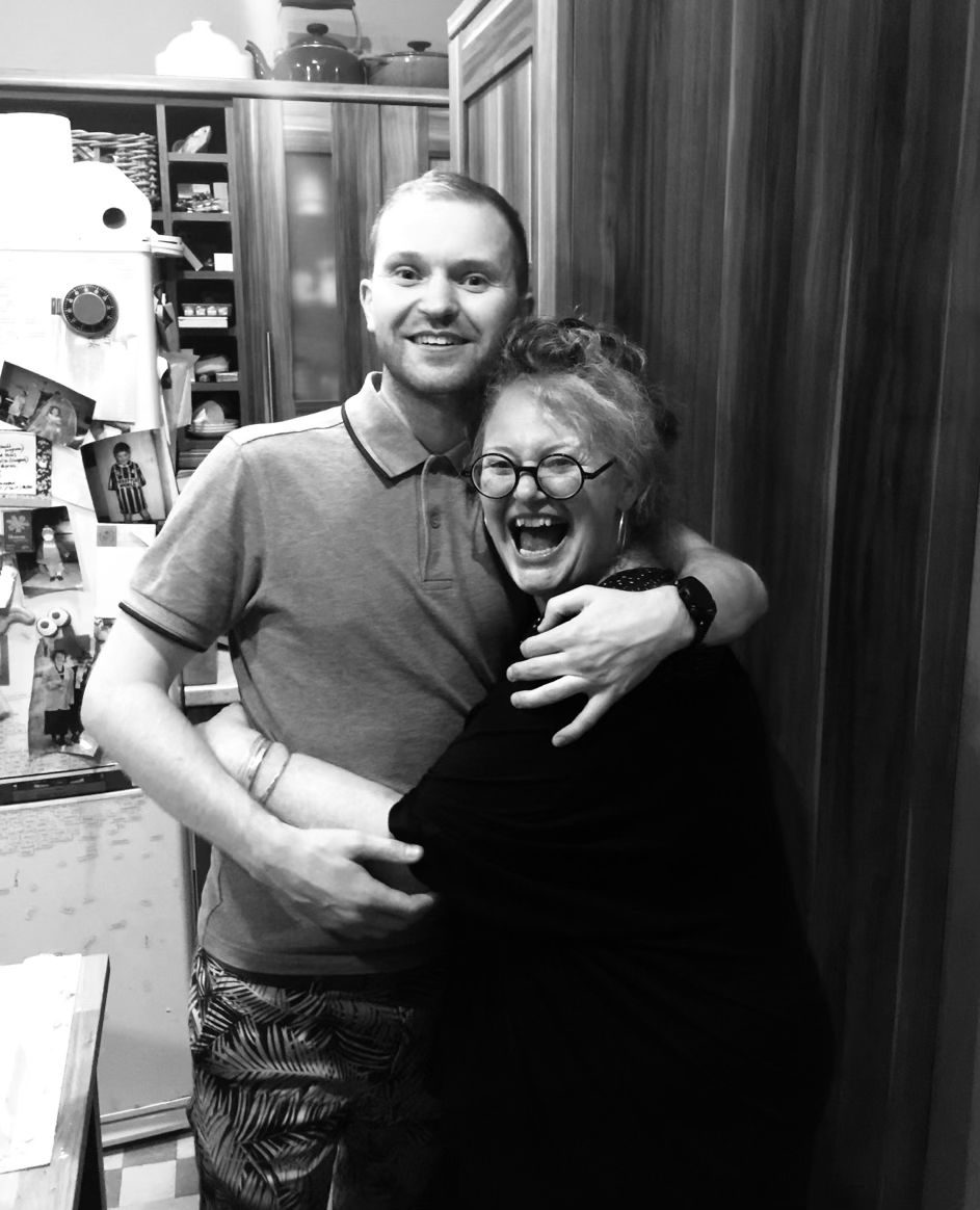 Callum Stewart and his mother, Jackie Marno-McGoldrick, laughing together in a kitchen.